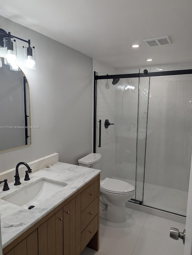 full bath featuring toilet, vanity, a stall shower, and visible vents