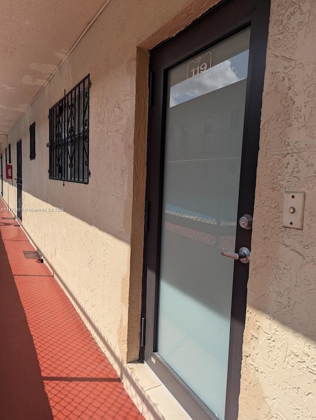 doorway to property featuring stucco siding