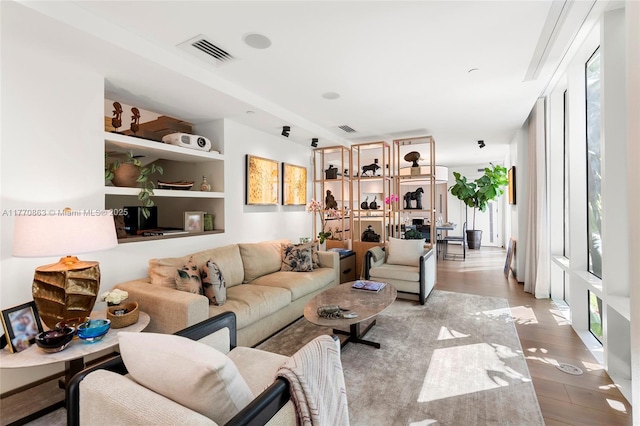 living room featuring visible vents and wood finished floors