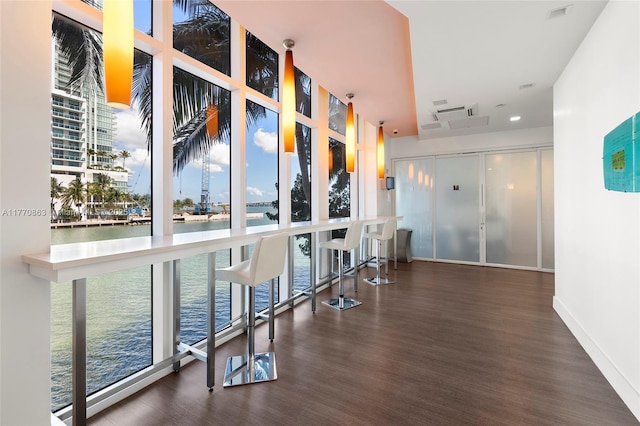 hall with a water view, a wealth of natural light, and wood finished floors
