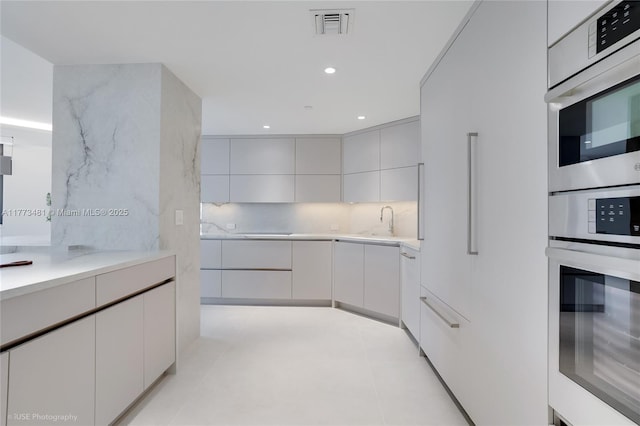 3201 S Ocean Blvd Unit 704, Highland Beach, FL 33487 - kitchen featuring modern cabinets, light countertops, a sink, backsplash, and recessed lighting