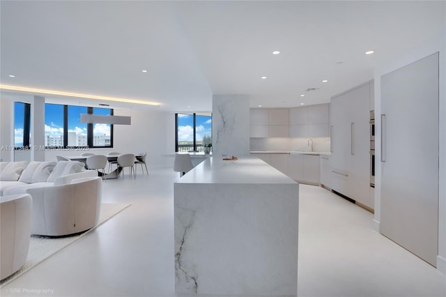 3201 S Ocean Blvd Unit 704, Highland Beach, FL 33487 - kitchen with modern cabinets, a sink, white cabinetry, light countertops, and recessed lighting