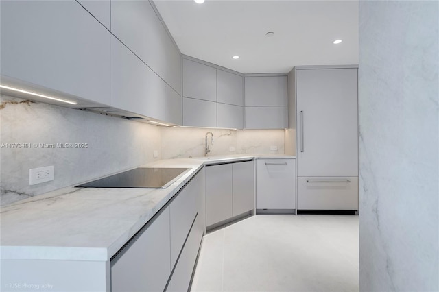 3201 S Ocean Blvd Unit 704, Highland Beach, FL 33487 - kitchen featuring black electric cooktop, a sink, tasteful backsplash, modern cabinets, and light countertops