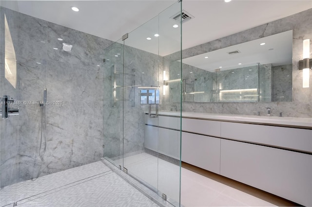 3201 S Ocean Blvd Unit 704, Highland Beach, FL 33487 - bathroom featuring a marble finish shower, double vanity, tile walls, and recessed lighting