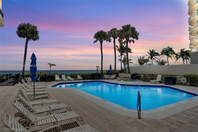 3201 S Ocean Blvd Unit 704, Highland Beach, FL 33487 - pool at dusk featuring a patio area, a community pool, and a water view