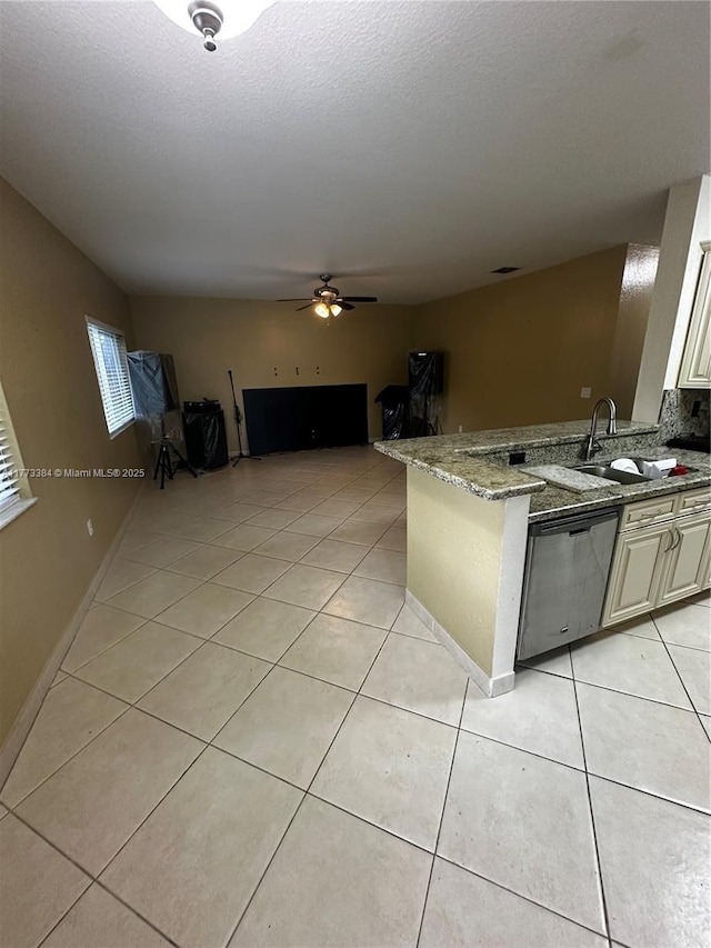 kitchen with dishwasher, light tile patterned floors, a sink, and a peninsula