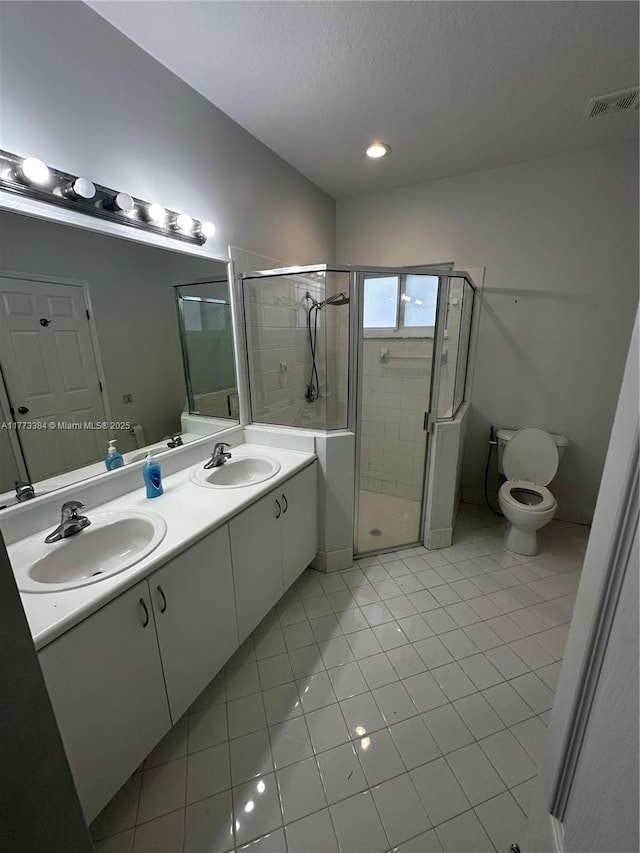 bathroom with visible vents, a sink, a stall shower, and tile patterned floors