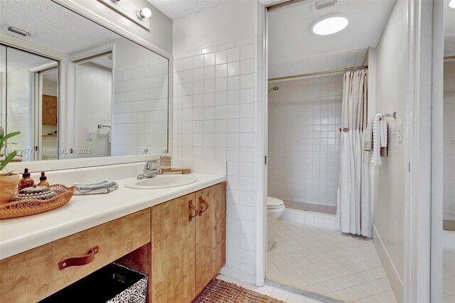 13701 SW 12th St Unit 310A, Pembroke Pines, FL 33027 - bathroom featuring toilet, tile patterned floors, vanity, tiled shower, and a textured ceiling