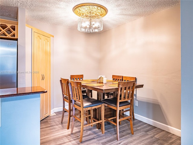 6545 W 27th Ct Unit 24-47, Hialeah, FL 33016 - dining space featuring a textured ceiling, wood finished floors, and a chandelier