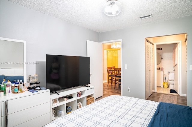 6545 W 27th Ct Unit 24-47, Hialeah, FL 33016 - bedroom with a textured ceiling, wood finished floors, and ensuite bath