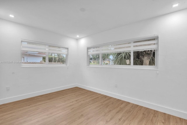 spare room featuring light wood-style floors, recessed lighting, and baseboards