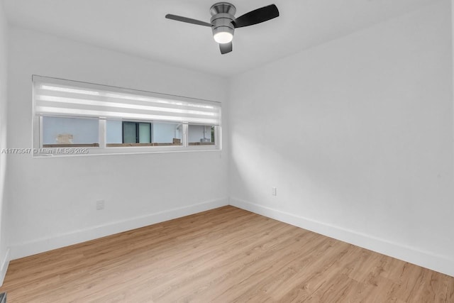 spare room featuring baseboards, ceiling fan, and wood finished floors