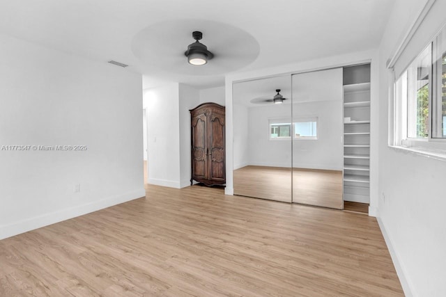 unfurnished bedroom with multiple windows, light wood-style flooring, and visible vents