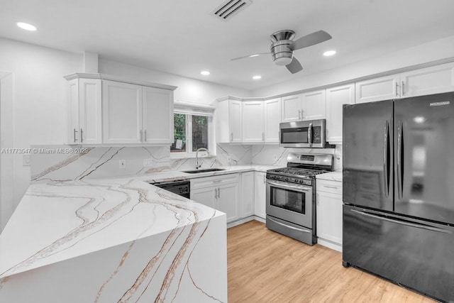 kitchen with ceiling fan, visible vents, a sink, light stone counters, and stainless steel appliances