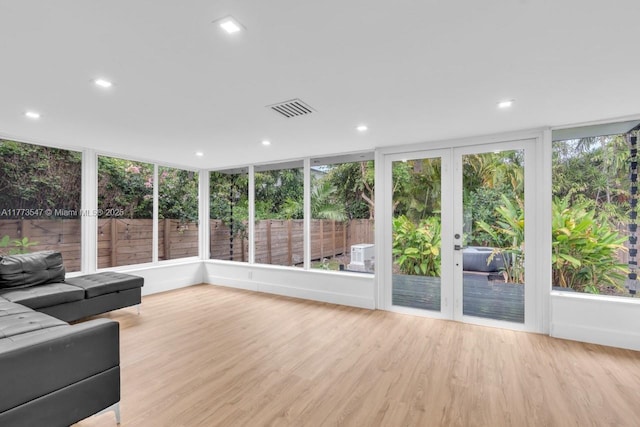 unfurnished sunroom featuring visible vents, wood finished floors, and a deck