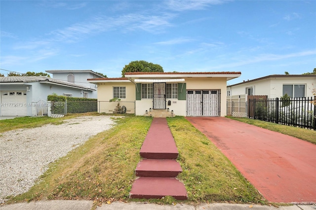 view of front of property with stucco siding, fence, driveway, a gate, and a garage