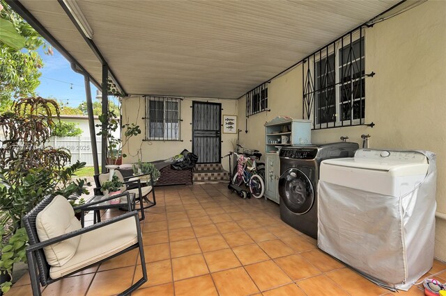 view of patio with independent washer and dryer, a carport, and fence