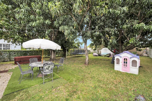 view of yard featuring a trampoline and a fenced backyard
