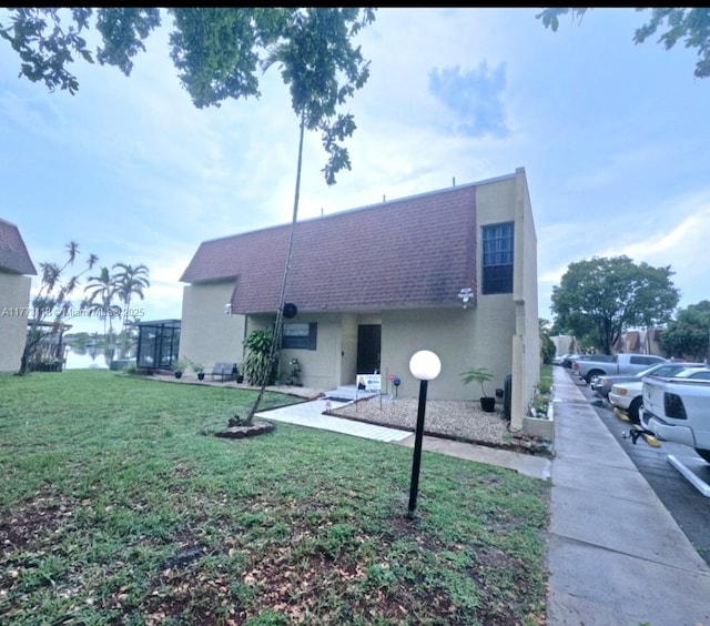 8920 Palm Tree Ln Unit 8920, Pembroke Pines, FL 33024 - back of property with a shingled roof, stucco siding, and a lawn