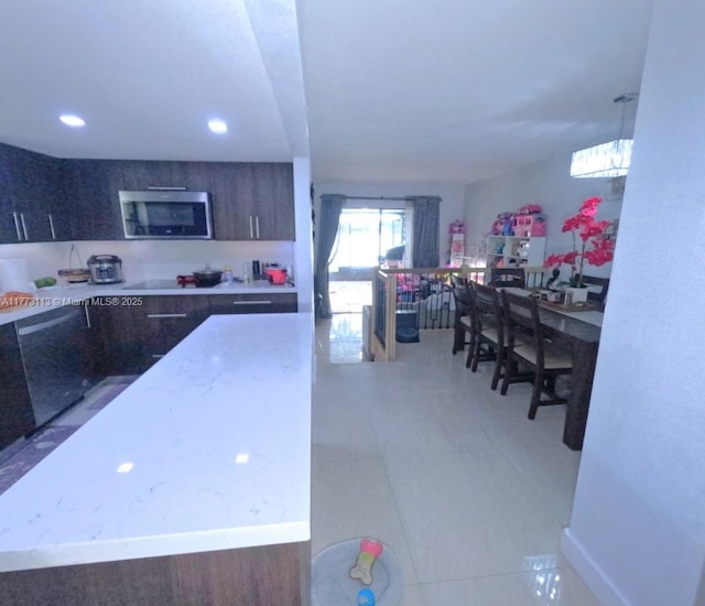 8920 Palm Tree Ln Unit 8920, Pembroke Pines, FL 33024 - kitchen with stainless steel microwave, tile patterned floors, and dark brown cabinetry