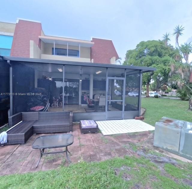 8920 Palm Tree Ln Unit 8920, Pembroke Pines, FL 33024 - rear view of house featuring a patio, a sunroom, stucco siding, outdoor lounge area, and a yard