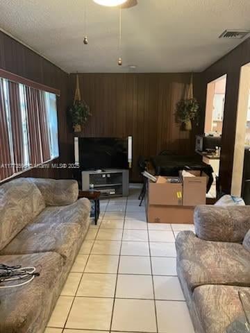 1010 NW 57th St, Miami, FL 33127 - living area featuring wood walls, light tile patterned flooring, and healthy amount of natural light