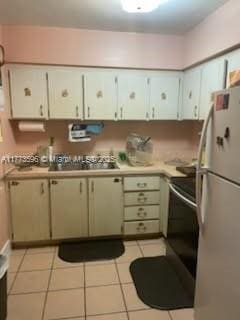 1010 NW 57th St, Miami, FL 33127 - kitchen with freestanding refrigerator, light countertops, electric range oven, and light tile patterned floors