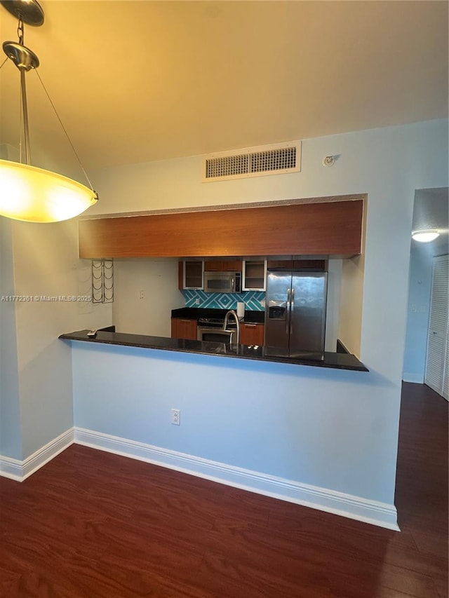 1800 N Bayshore Dr Unit 1404, Miami, FL 33132 - kitchen featuring appliances with stainless steel finishes, dark wood finished floors, baseboards, dark countertops, and a peninsula