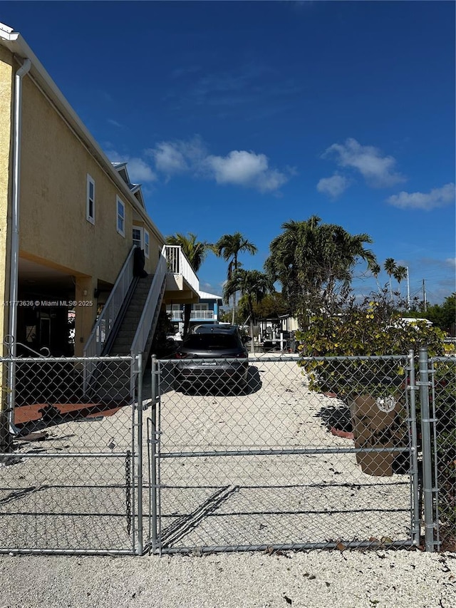 view of gate featuring stairway and fence