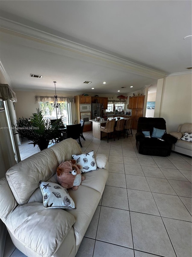 living area with ornamental molding, visible vents, a chandelier, and light tile patterned floors