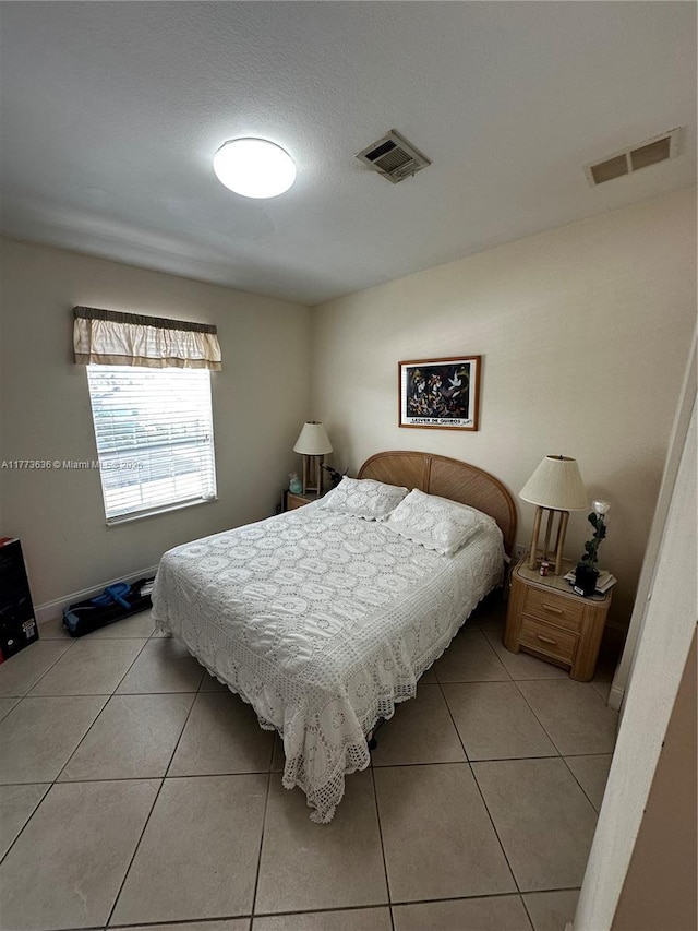 bedroom featuring light tile patterned floors, baseboards, and visible vents