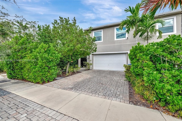 709 SW 17th St, Fort Lauderdale, FL 33315 - view of front of property with stucco siding, decorative driveway, and a garage