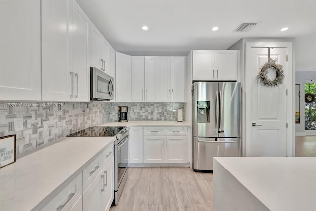 709 SW 17th St, Fort Lauderdale, FL 33315 - kitchen with visible vents, white cabinetry, backsplash, light countertops, and appliances with stainless steel finishes
