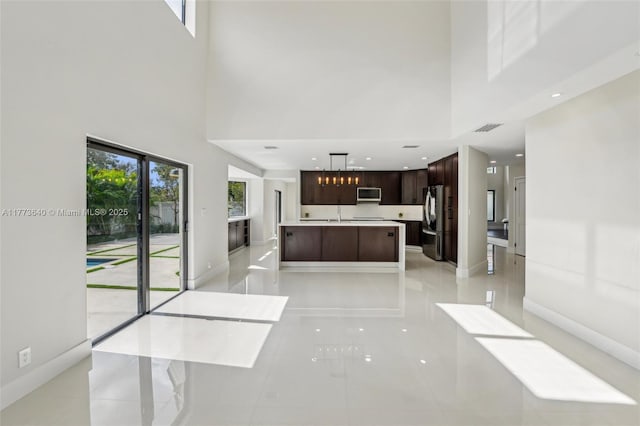 20160 NW 9th Dr, Pembroke Pines, FL 33029 - unfurnished living room with a towering ceiling, light tile patterned floors, and recessed lighting