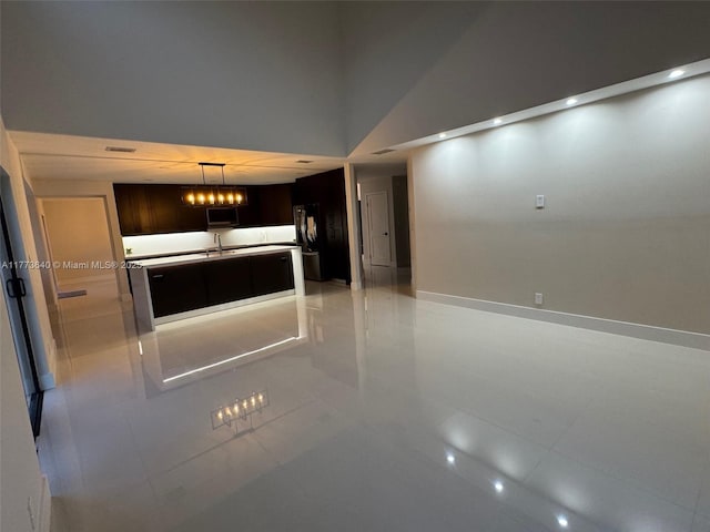 20160 NW 9th Dr, Pembroke Pines, FL 33029 - kitchen featuring a kitchen island with sink, dark brown cabinets, light tile patterned flooring, pendant lighting, and high vaulted ceiling