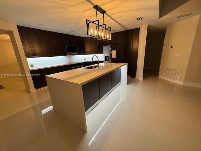 20160 NW 9th Dr, Pembroke Pines, FL 33029 - kitchen featuring stainless steel refrigerator with ice dispenser, light countertops, dark brown cabinets, and decorative light fixtures