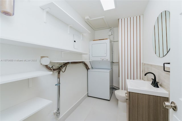 219 NE 11th Ave Unit 2, Hallandale Beach, FL 33009 - bathroom with stacked washer / drying machine, toilet, tile patterned floors, and vanity