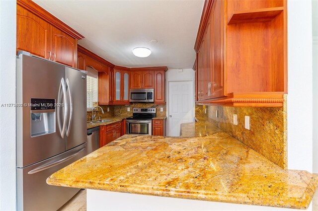 219 NE 11th Ave Unit 2, Hallandale Beach, FL 33009 - kitchen featuring a sink, stainless steel appliances, a peninsula, and tasteful backsplash