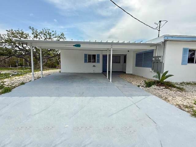 view of front of home with an attached carport, stucco siding, and concrete driveway