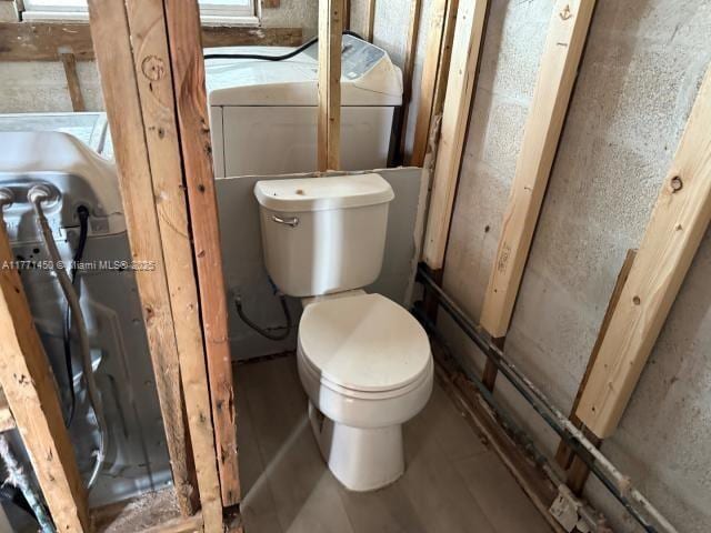 bathroom featuring toilet and washer / clothes dryer