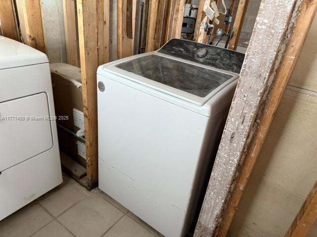 laundry room with tile patterned flooring, washer / clothes dryer, and laundry area