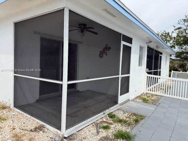 view of property exterior with stucco siding and a sunroom