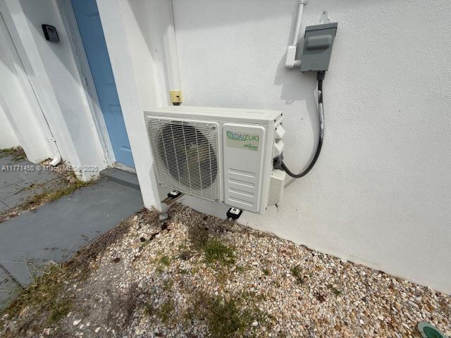 details featuring ac unit and stucco siding