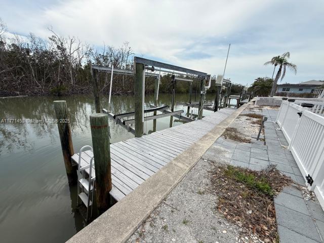 dock area with a water view and boat lift