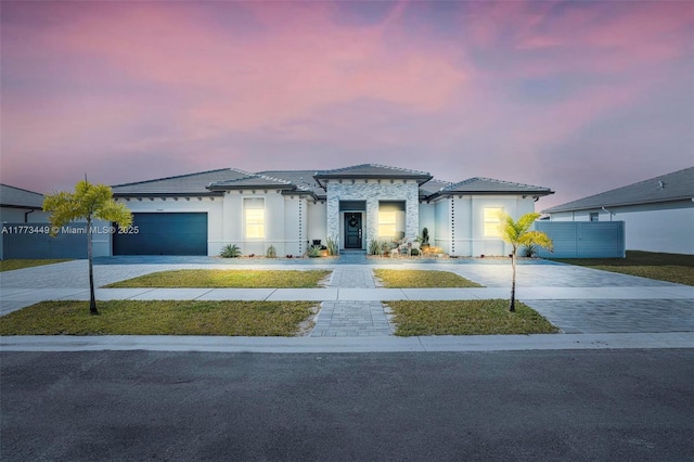 view of front of property featuring concrete driveway, an attached garage, and stucco siding