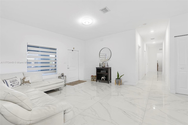living area with baseboards, visible vents, and marble finish floor