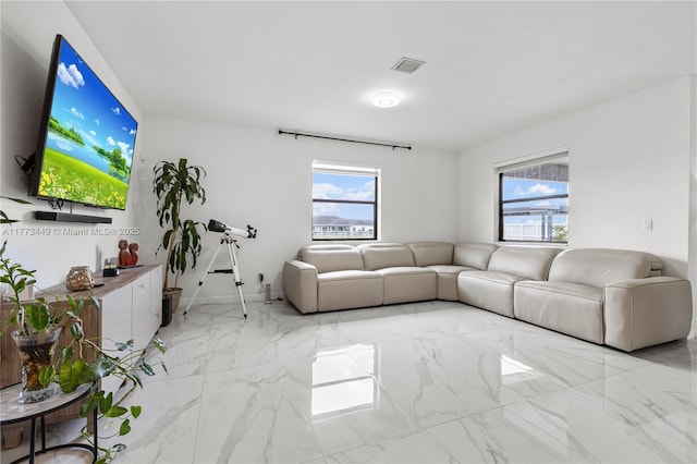 living area with visible vents, a healthy amount of sunlight, and marble finish floor