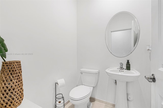 half bath with toilet and tile patterned flooring