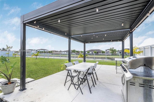 view of patio with a water view, a fenced backyard, grilling area, and outdoor dining space