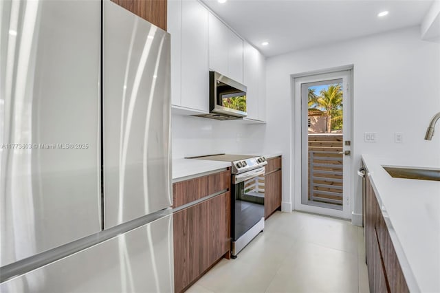 kitchen featuring light countertops, a sink, appliances with stainless steel finishes, modern cabinets, and white cabinets